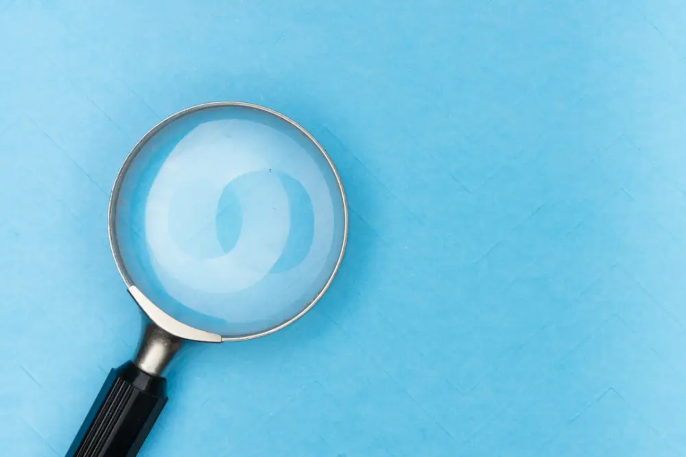 Magnifying glass on white table, illustrating maintaining an intentional editorial scope